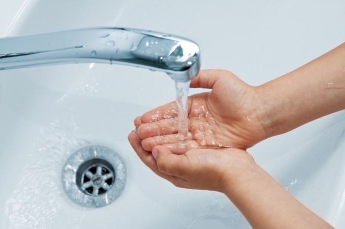 Hands washing water under tap flowing closeup stock